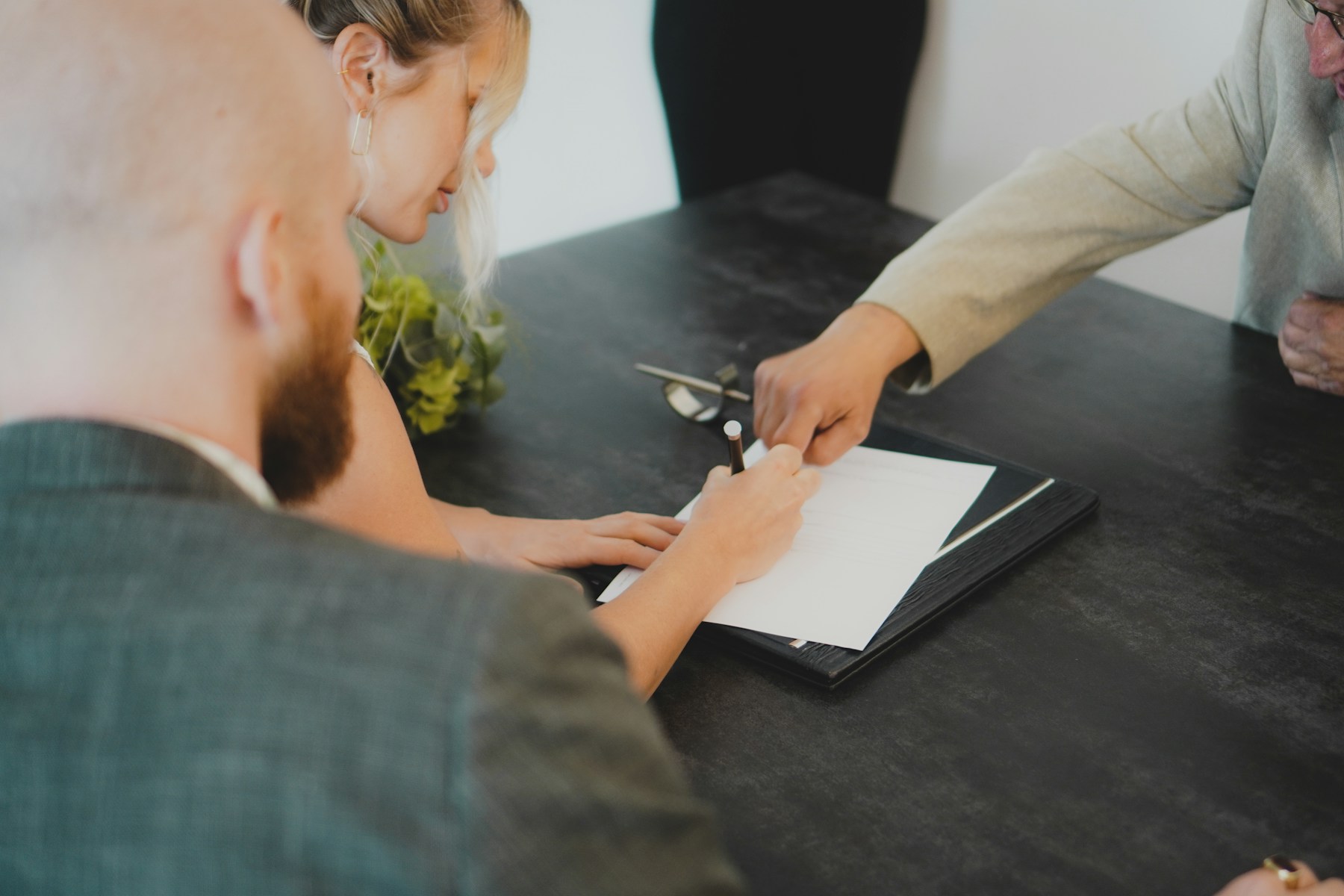 Pessoas analisando e assinando documentos em uma mesa